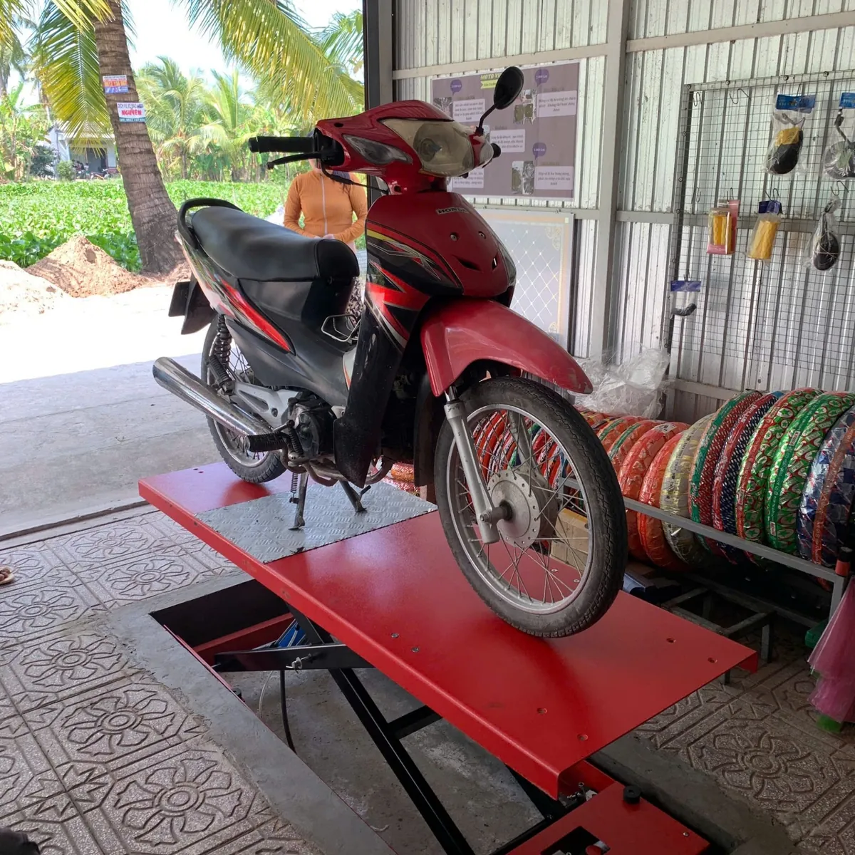 Nhiều bàn nâng xe máy đặt âm nền Lộc Phát BNAN-HY01 được lắp đặt thẳng hàng trong không gian garage.