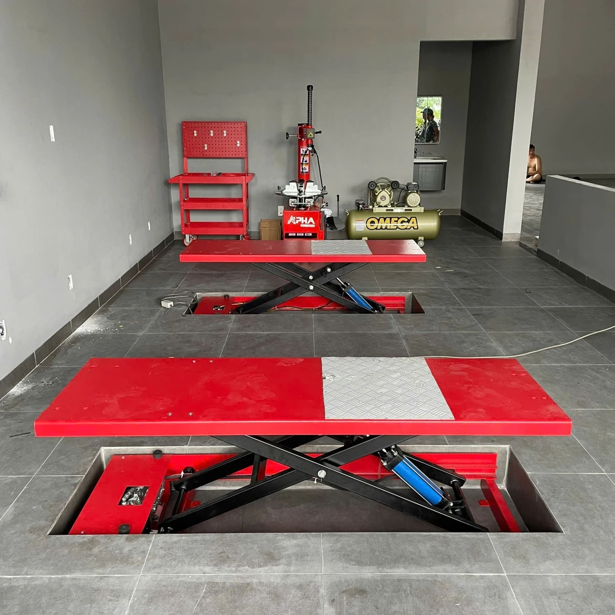 Bàn nâng xe máy đặt âm nền Lộc Phát BNAN-HY01 hoạt động trong không gian garage, cho thấy tính ứng dụng thực tế.