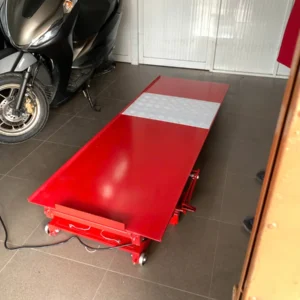 Bàn nâng xe máy điện và cơ Lộc Phát BXMDC đang nâng một chiếc xe máy để thợ sửa chữa, minh họa rõ nét tính năng sử dụng.