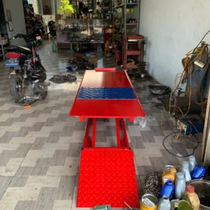 Hình ảnh thực tế bàn nâng xe máy Lộc Phát đang nâng một chiếc xe máy để sửa chữa trong garage.