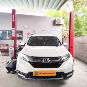 Cầu nâng ô tô 2 trụ Suntek 4000D đang nâng một chiếc xe SUV màu trắng.