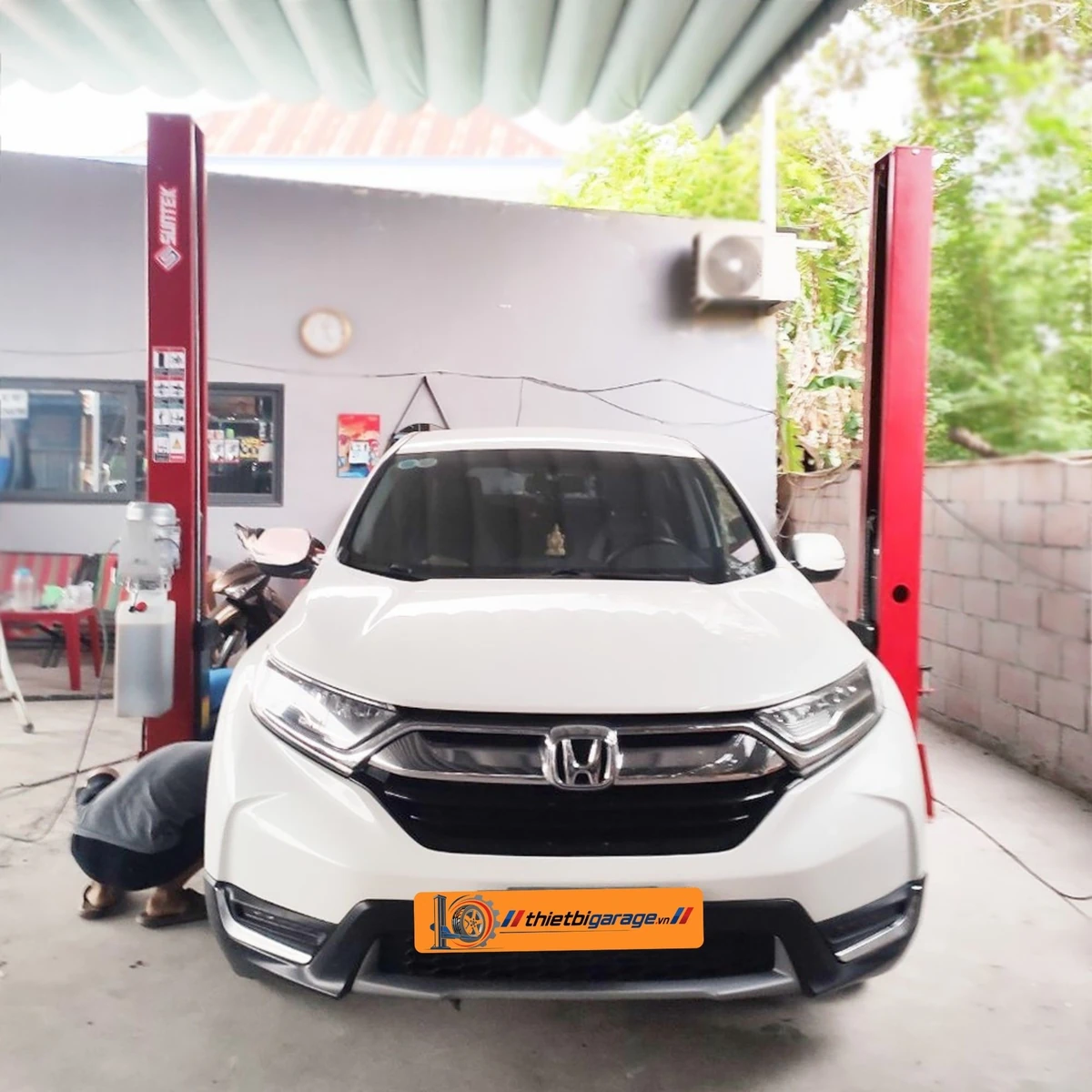 Cầu nâng ô tô 2 trụ Suntek 4000D đang nâng một chiếc xe SUV màu trắng.