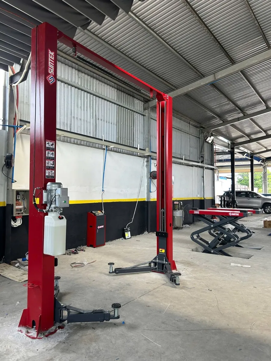 Cầu nâng ô tô 2 trụ Suntek-4000T đang nâng một chiếc xe tải nhỏ.