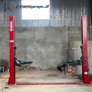 Cầu nâng ô tô 2 trụ Suntek 4000D màu đỏ, lắp đặt trong gara sửa chữa.