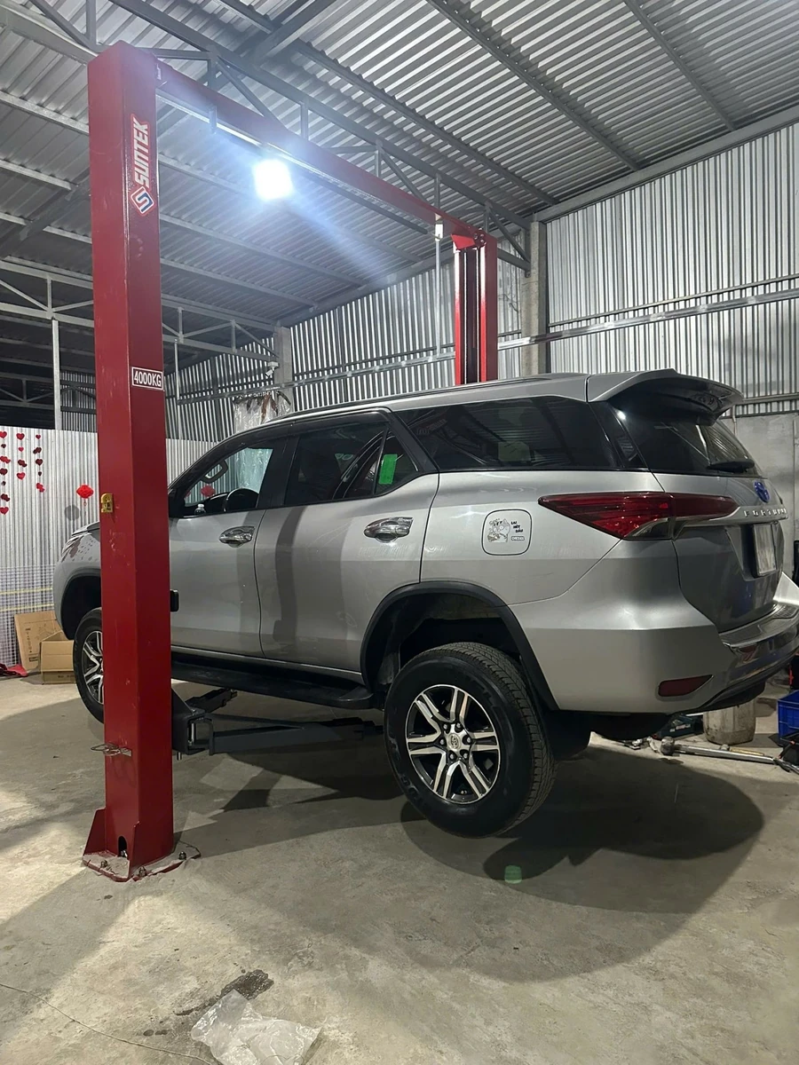 Cầu nâng ô tô 2 trụ Suntek-4000T được lắp đặt trong một gara rộng rãi, hiện đại.