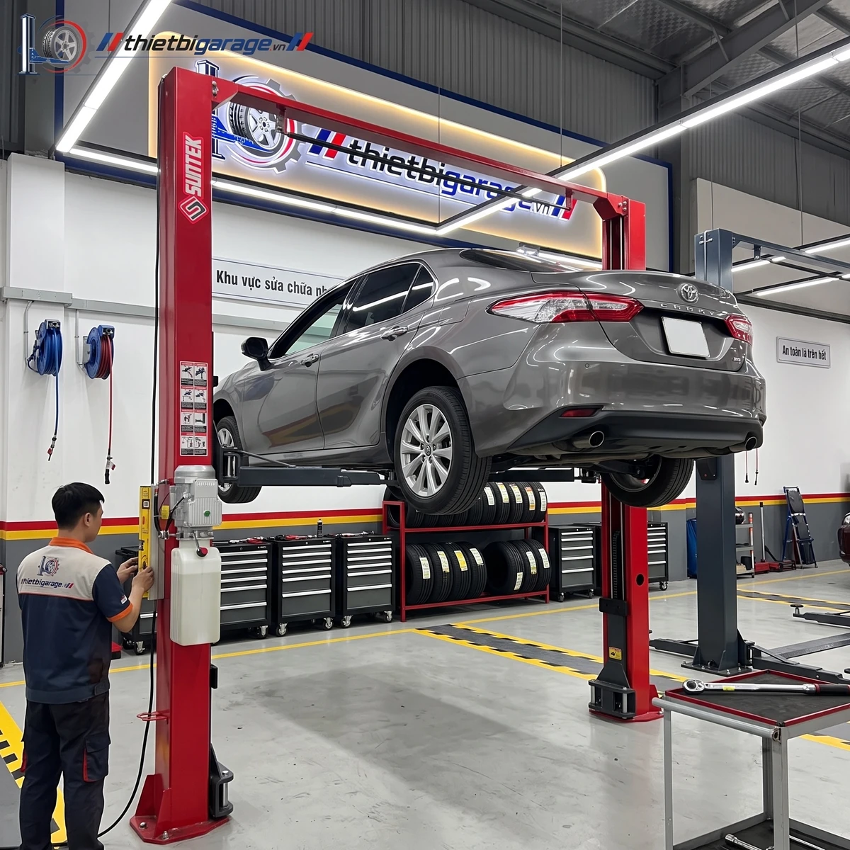 Cầu nâng ô tô 2 trụ Suntek-4000T chính hãng, màu đỏ, lắp đặt trong gara.