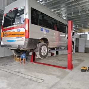 Cầu nâng ô tô 2 trụ cổng dưới Suntek 4000D đang hoạt động trong một xưởng sửa chữa.