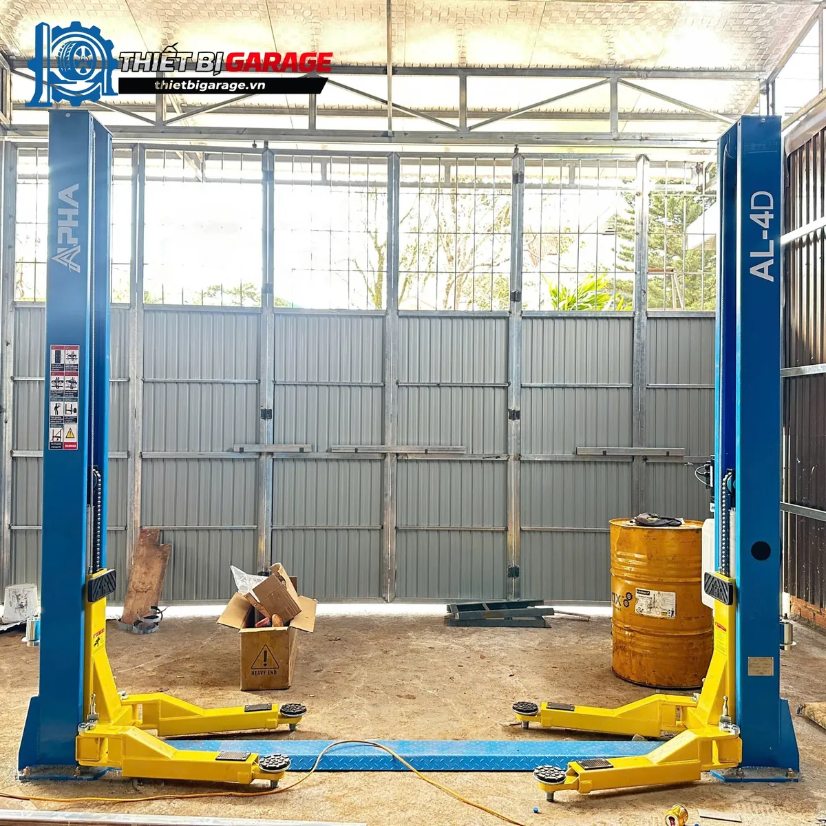 Cầu nâng ô tô 2 trụ Alpha AL-4D lắp đặt trong một garage sửa chữa xe.