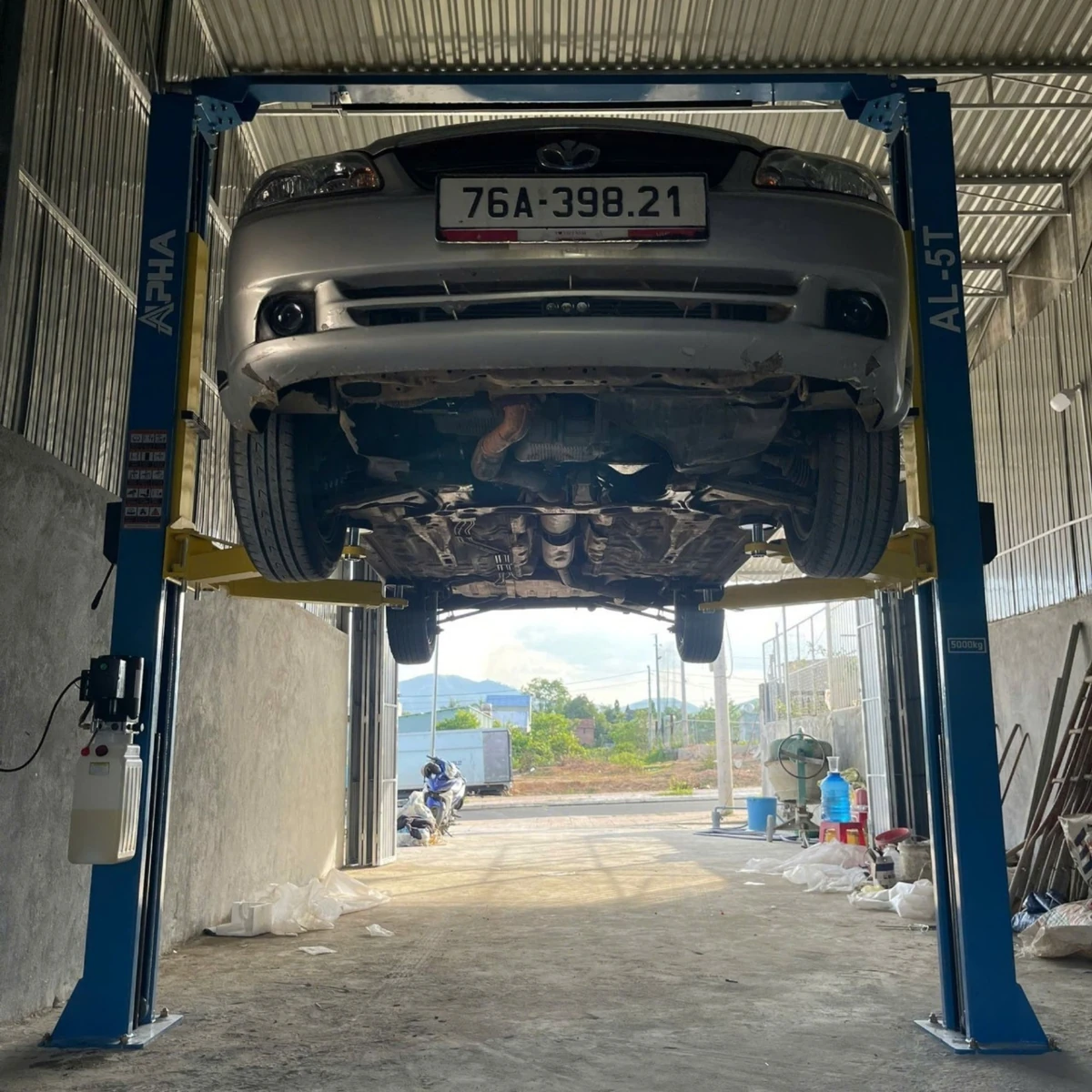 Cầu nâng ô tô 2 trụ Alpha AL-5T nâng xe từ phía trước, lộ rõ gầm xe.