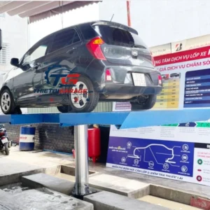 Cầu nâng 1 trụ AIRTEK-CB đang hoạt động, nâng xe Kia Morning tại garage chuyên nghiệp.