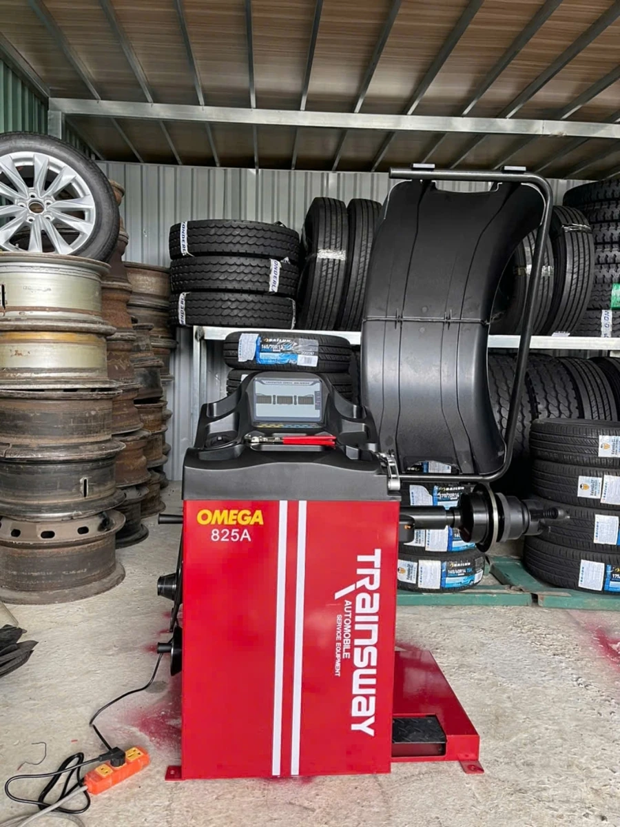 Máy cân bằng lốp ô tô OMEGA-825A, thiết bị Lộc Phát, đặt trong garage.
