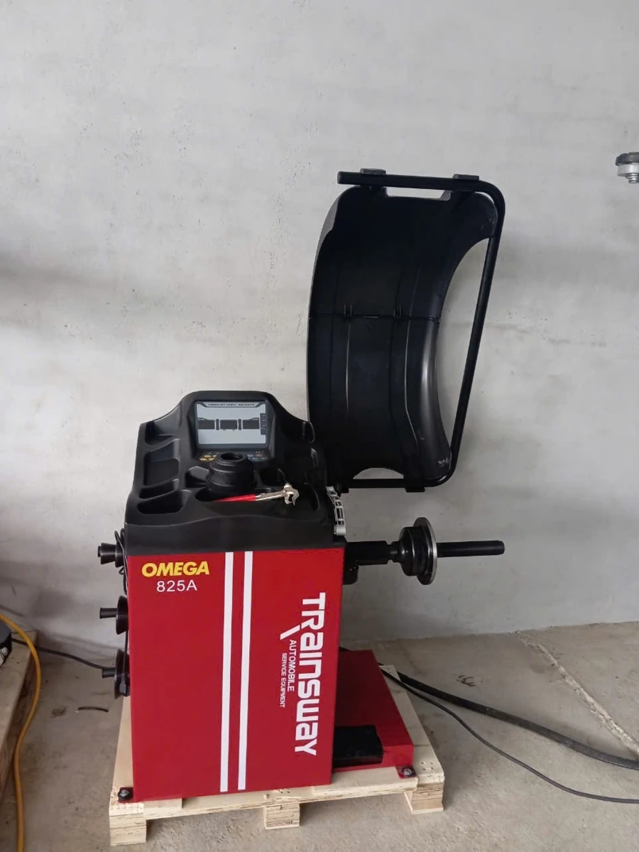 Máy cân bằng lốp ô tô OMEGA-825A, thiết bị Lộc Phát, đặt trong garage.
