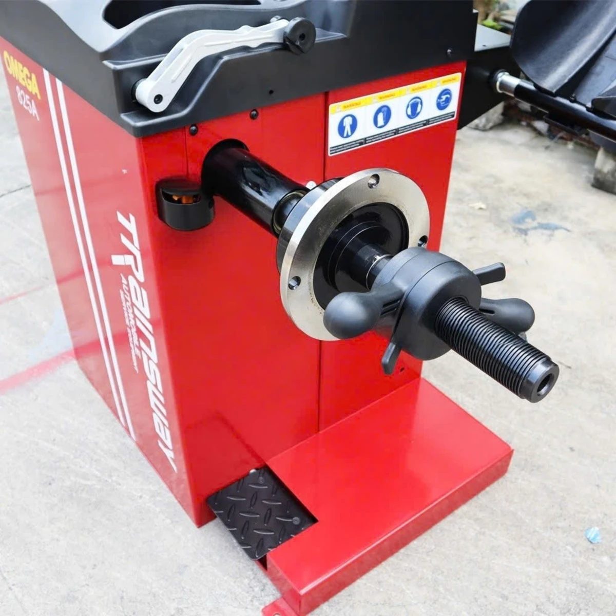 Máy cân bằng lốp ô tô OMEGA-825A, thiết bị Lộc Phát, đặt trong garage.