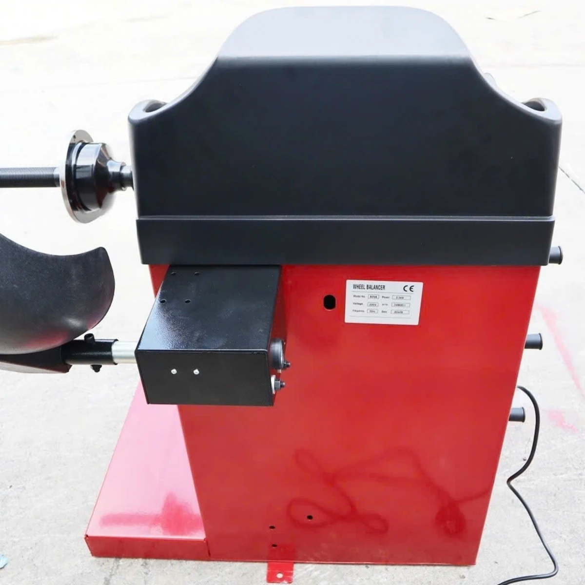 Máy cân bằng lốp ô tô OMEGA-825A, thiết bị Lộc Phát, đặt trong garage.