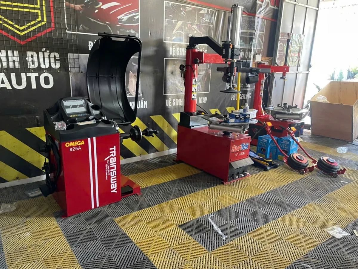 Máy cân bằng lốp ô tô OMEGA-825A, thiết bị Lộc Phát, đặt trong garage.