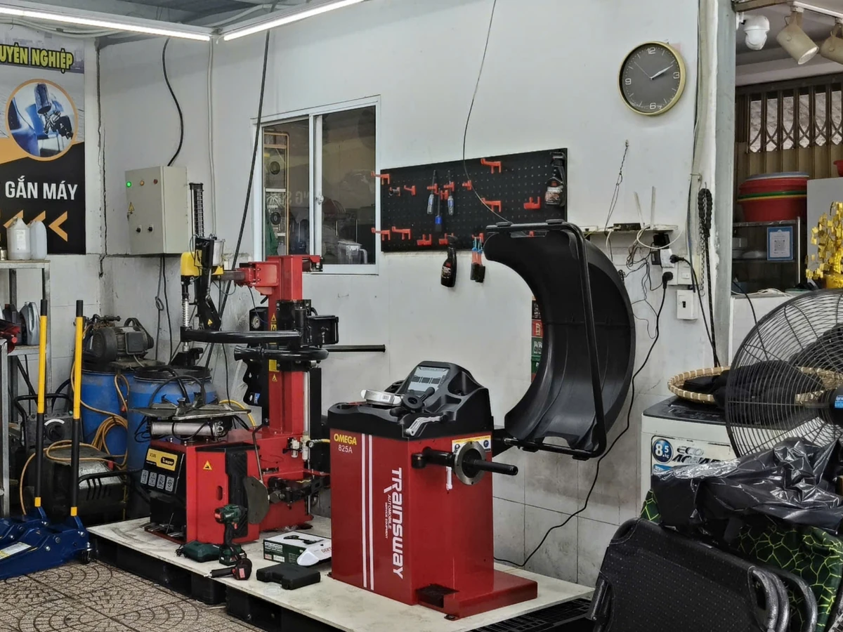 Máy cân bằng lốp ô tô OMEGA-825A, thiết bị Lộc Phát, đặt trong garage.