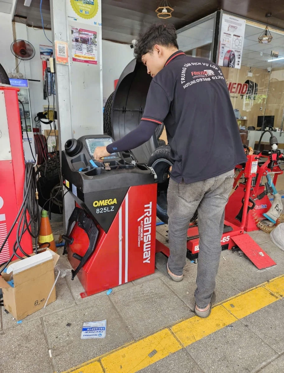 Kỹ thuật viên đang vận hành máy cân bằng lốp ô tô Omega-Trainsway 825LZ Lộc Phát chính hãng.