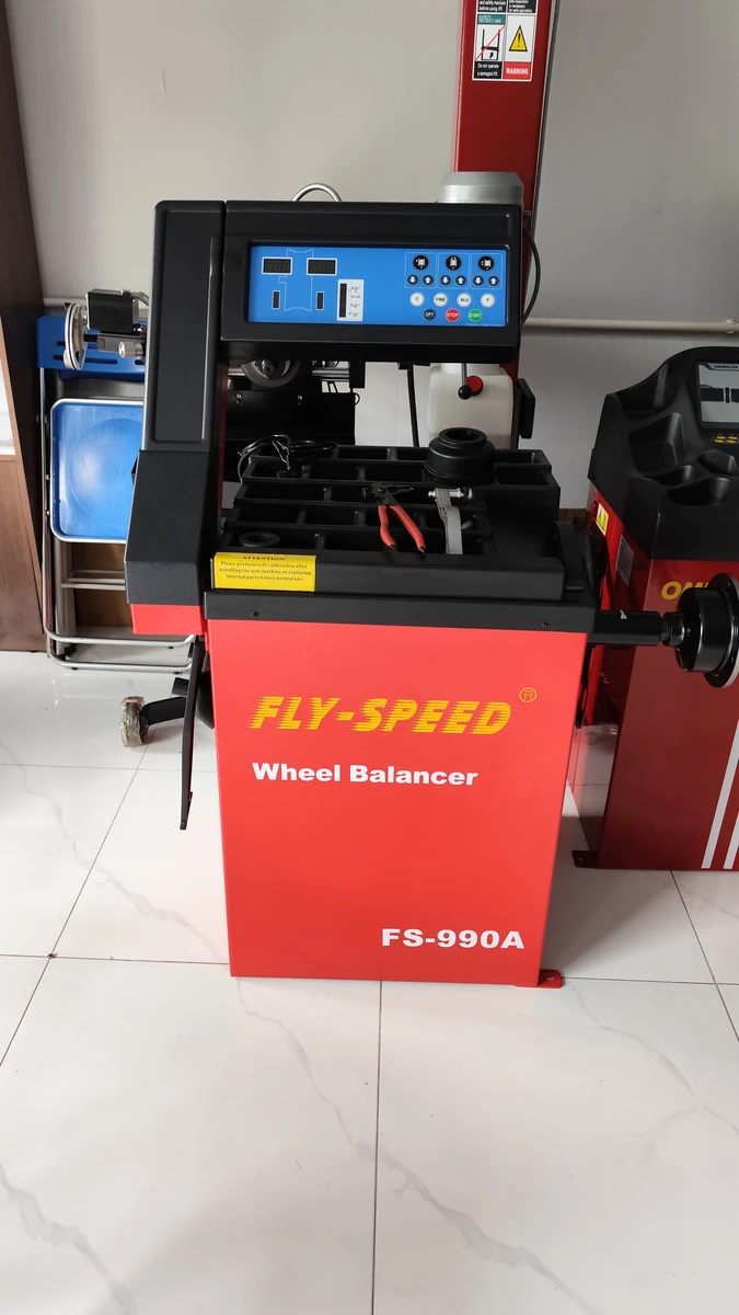 Máy Cân Bằng Lốp Fly-Speed FS-990A Tại Garage Hiện Đại Máy cân bằng lốp Fly-Speed FS-990A trong garage hiện đại, thiết bị sửa chữa ô tô chuyên nghiệp, uy tín.