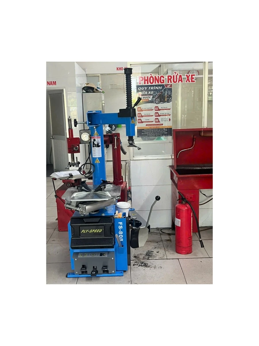 Máy tháo lốp Fly Speed FS-808 đặt cạnh máy nén khí LOPATEK, tạo thành bộ đôi thiết bị sửa chữa chuyên nghiệp.