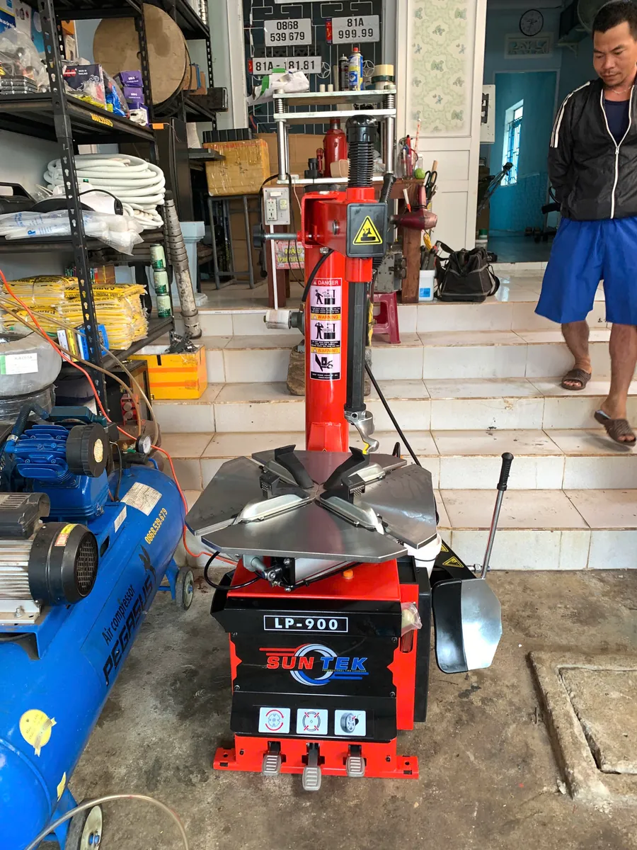 Máy tháo vỏ SunTek LP-900 đặt tại khu vực làm việc của garage, sẵn sàng sử dụng.