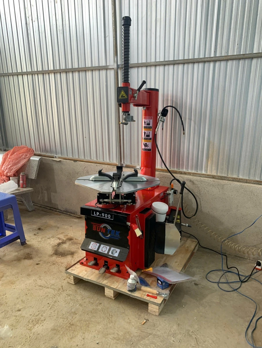 Máy tháo vỏ SunTek LP-900 đang tháo vỏ xe tay ga, với bánh xe được đặt trên mâm.