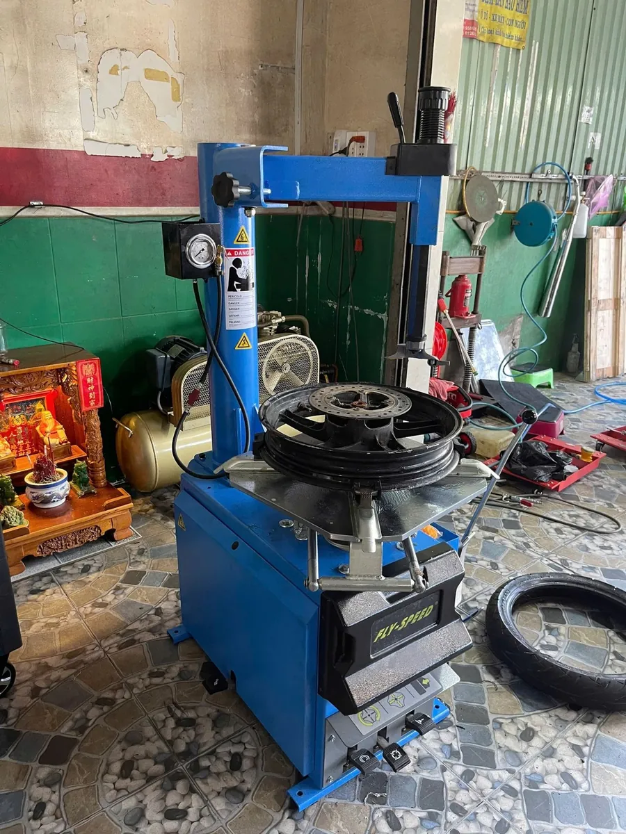Máy tháo lốp Fly Speed FS-808 đang thao tác với mâm xe ô tô, thể hiện khả năng làm việc đa dạng.