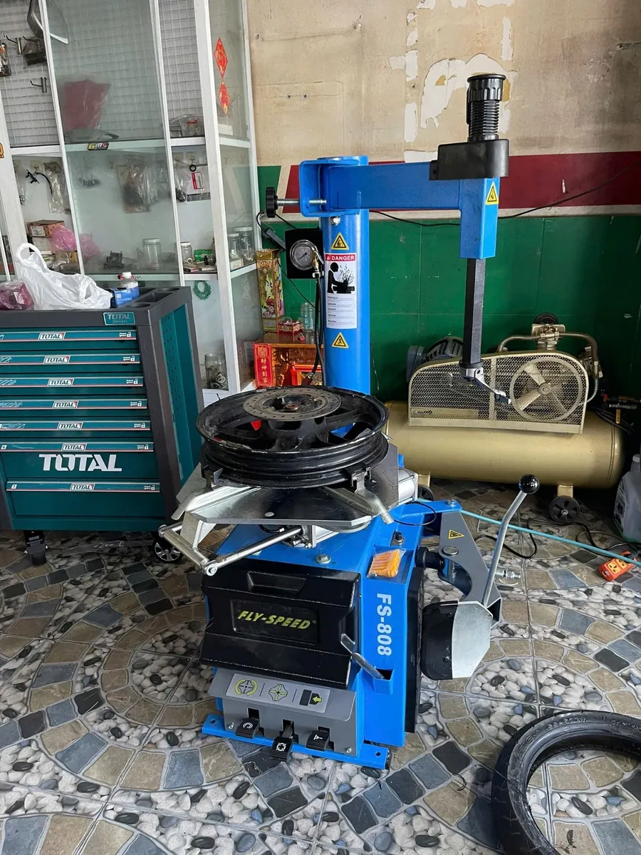 Máy tháo lốp Fly Speed FS-808 đang thao tác với mâm xe tay ga, thể hiện tính linh hoạt.
