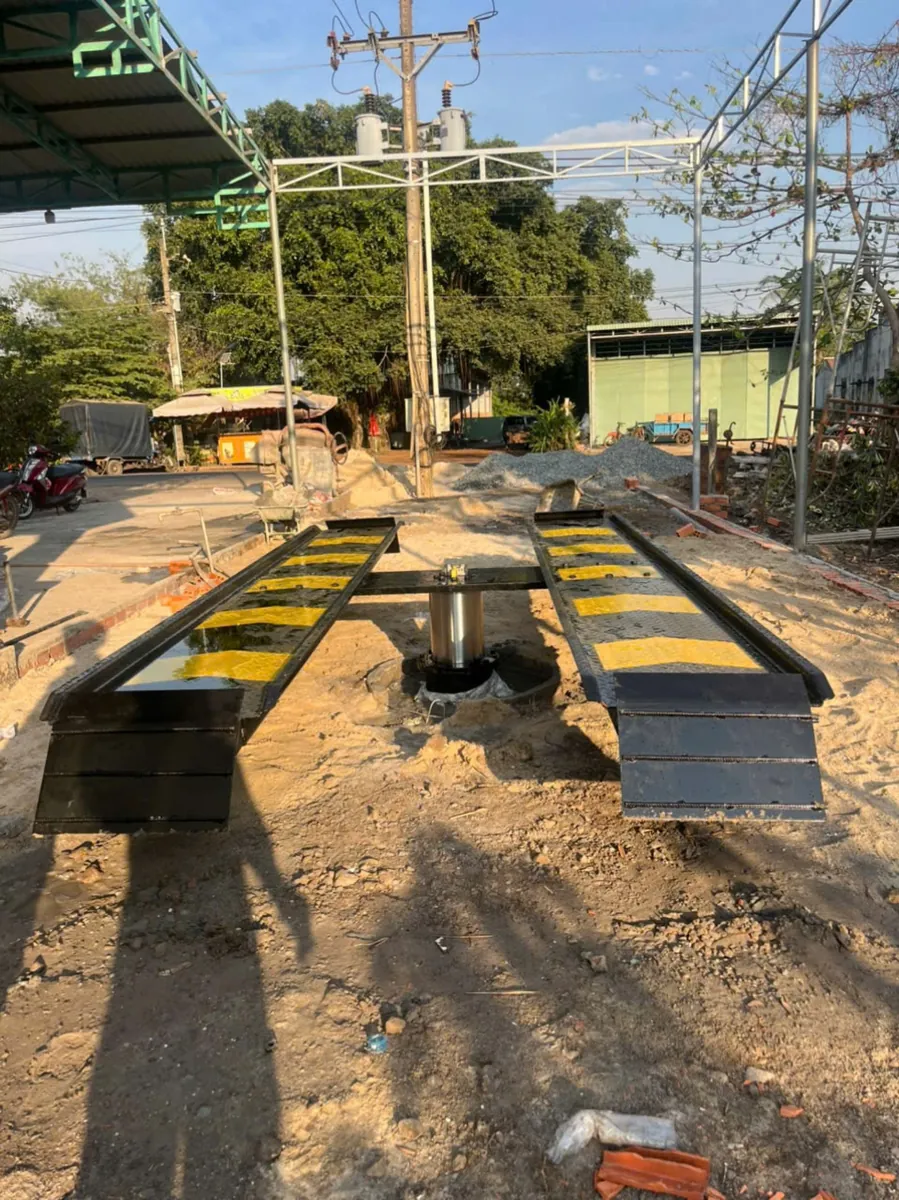 Thi công lắp đặt cầu nâng 1 trụ rửa xe ô tô tại xưởng, đội ngũ kỹ thuật viên đang tiến hành dựng cột.
