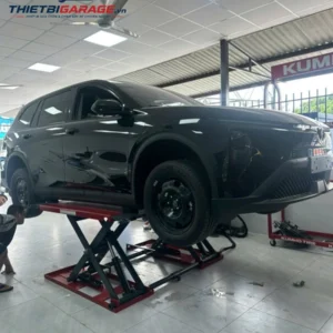 Cầu nâng ô tô cắt kéo Suntek 3000DX nâng xe tại garage sửa chữa chuyên nghiệp.