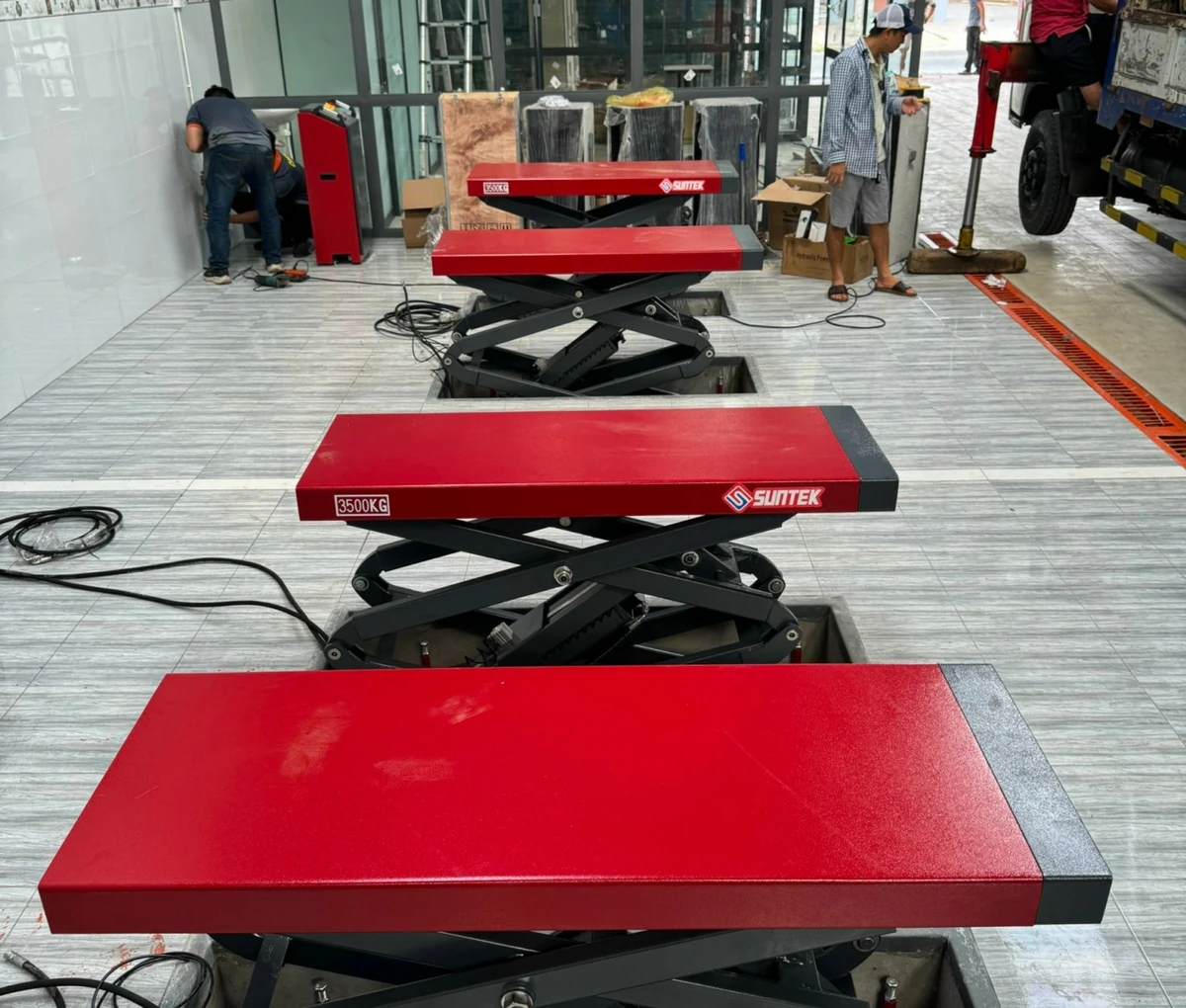 Cầu nâng ô tô kiểu xếp Suntek 3500S - Giải pháp tối ưu cho garage. Cầu nâng ô tô kiểu xếp Suntek 3500S 220V đang hoạt động tại garage, sẵn sàng nâng hạ xe sửa chữa.