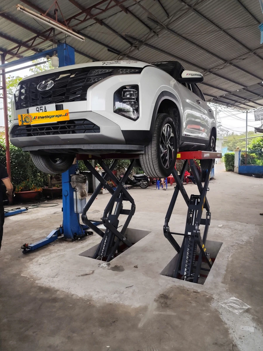 Cầu nâng ô tô Suntek 3500S kiểu xếp hoạt động thực tế Cầu nâng ô tô Suntek 3500S kiểu xếp đang nâng thử tải xe ô tô tại garage, công suất 3500kg.