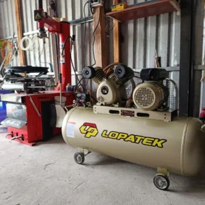 Máy nén khí Lopatek 3HP 200L 220v áp 12 đang hoạt động tại garage sửa chữa.