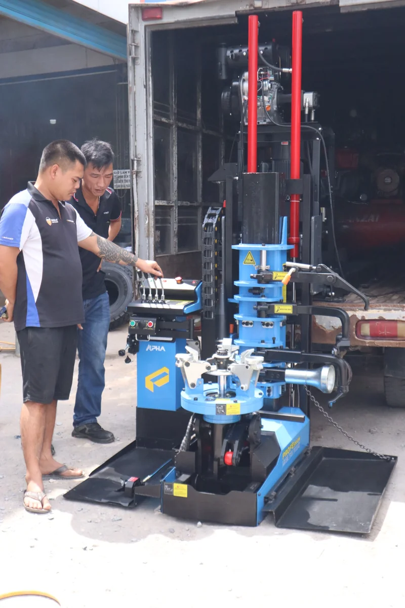 Kỹ thuật viên thao tác tay trang điều khiển thủy lực máy tháo lốp xe tải lưu động Alpha AL-1300-SDL2