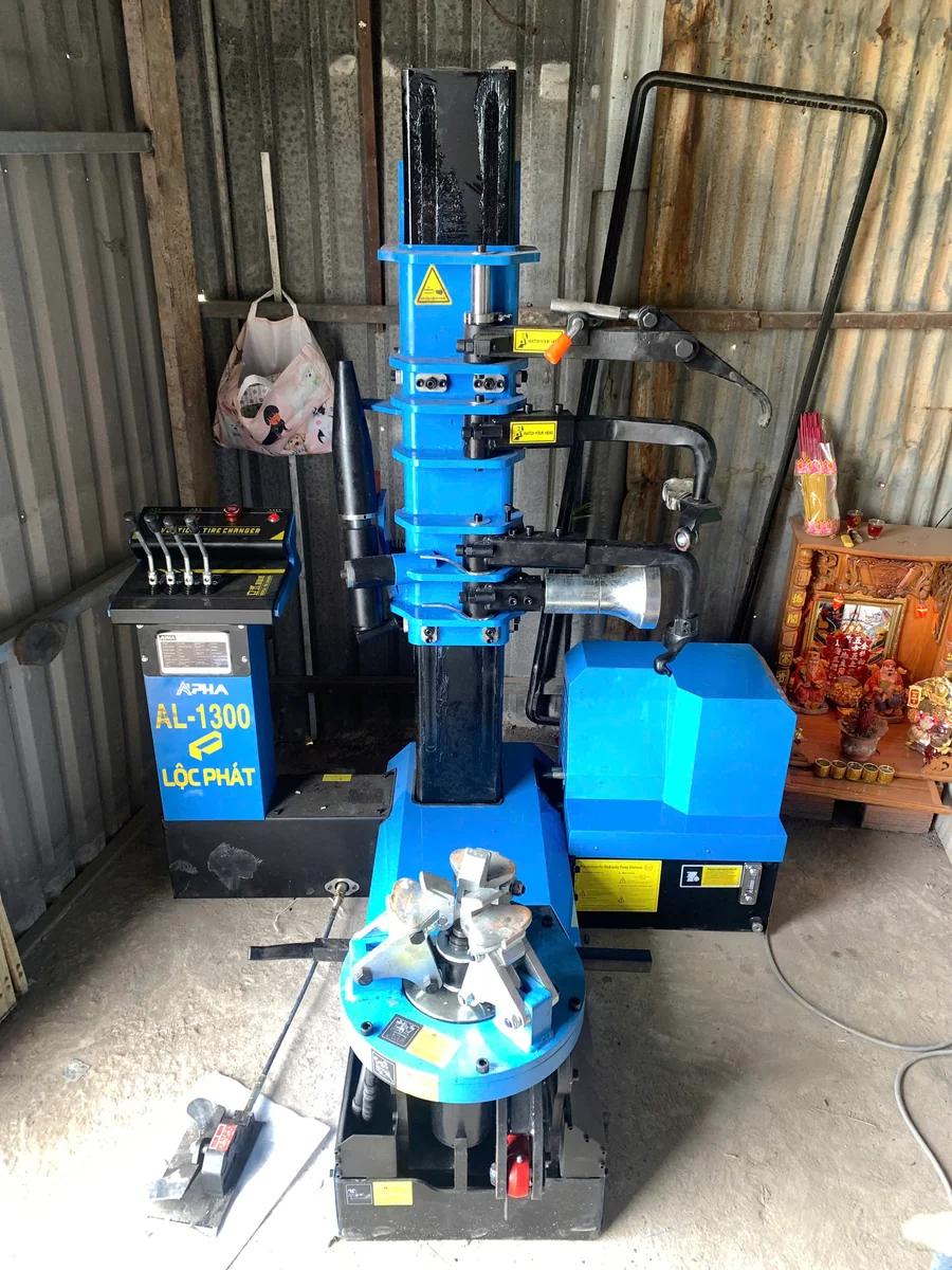 thợ gara Bình Tân vận hành máy tháo lốp xe tải Alpha AL-1300